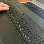 Jen reading a line of text on a 40-cell/40-characters refreshable braille display for one of her classes