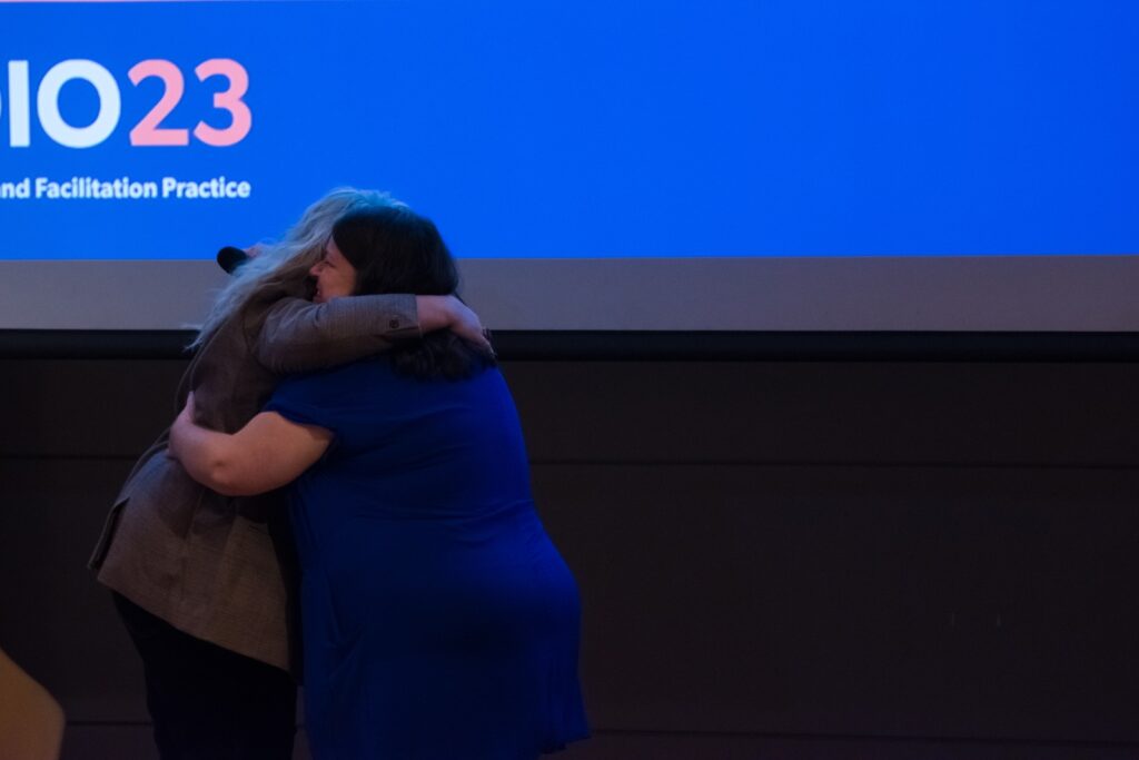 Two participants hugging during Day 2 of Studio 23.