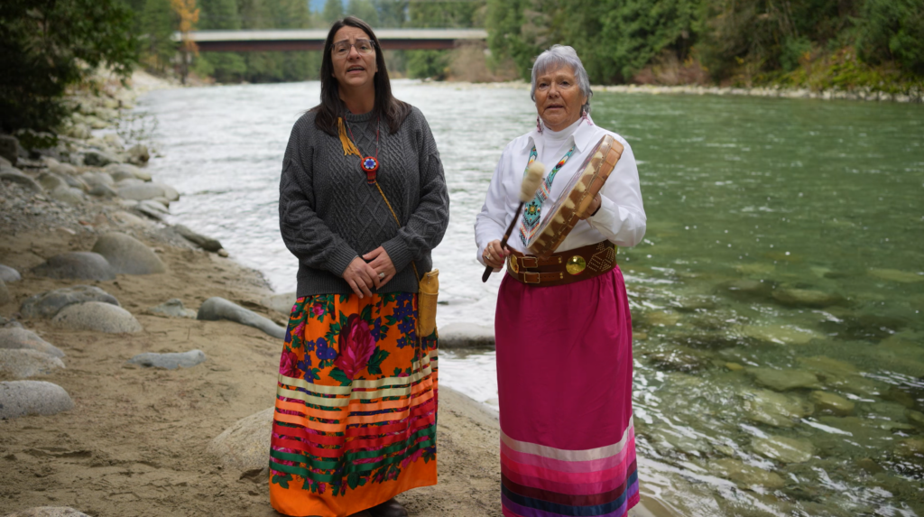Elder Buckshot and daughter singing and drumming by river