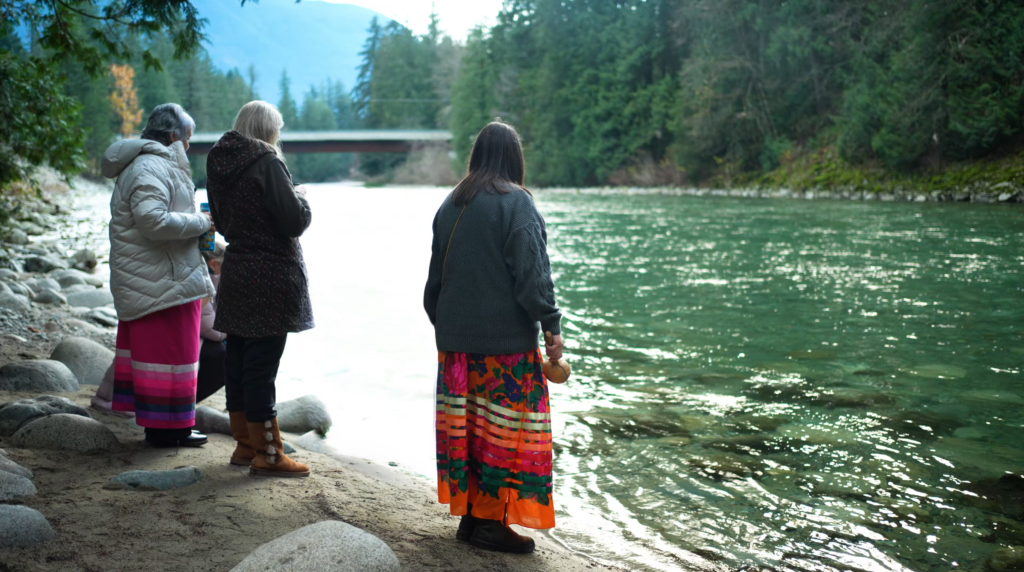 Project team standing by the water looking at a salmon.