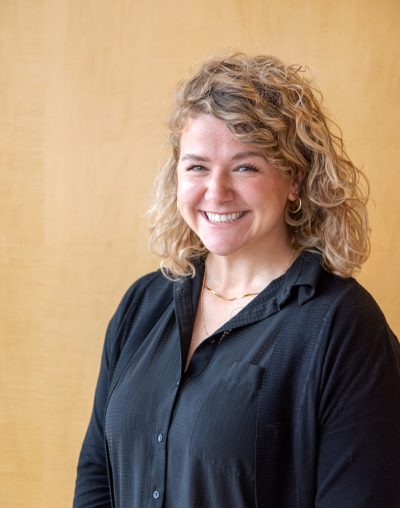 Headshot of Nina Bennett. Nina is dressed in a black cotton outfit.